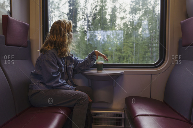 Woman traveling by train looking out of window
