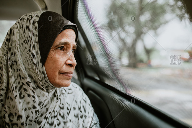 Portrait of Malaysian woman looking out window of car
