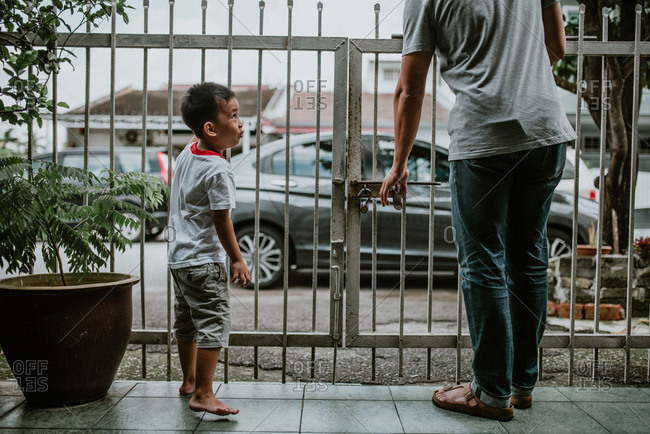 Boy and father standing at gate