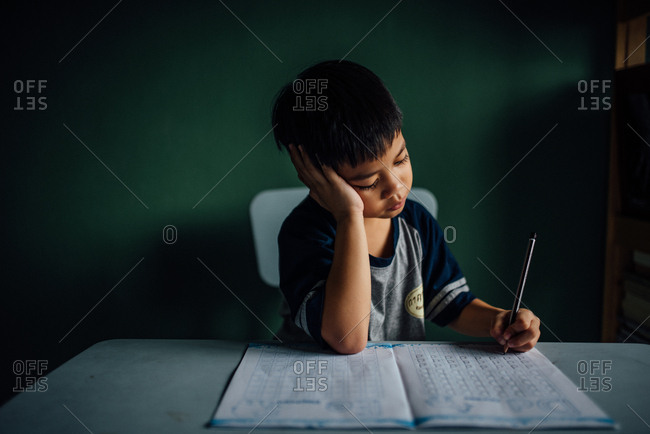 Boy sitting at table doing homework