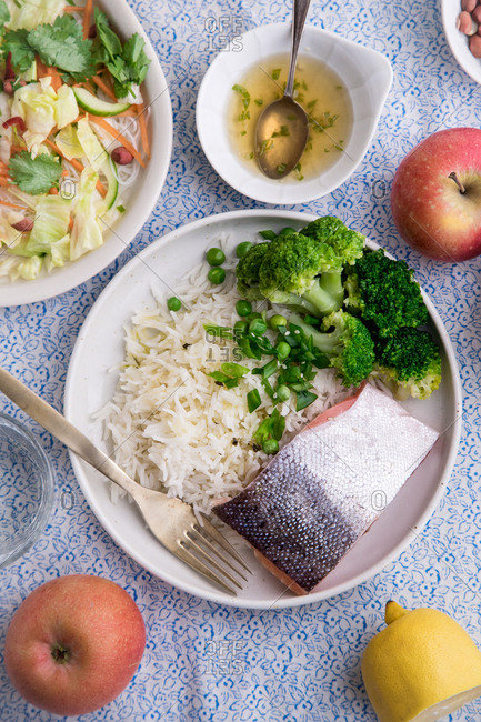 Healthy dinner with rice noodle salad, cooked salmon with basmati rice, broccoli and beans.