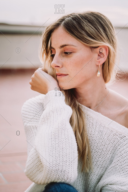 Beautiful woman with fair hair posing on rooftop stock photo - OFFSET