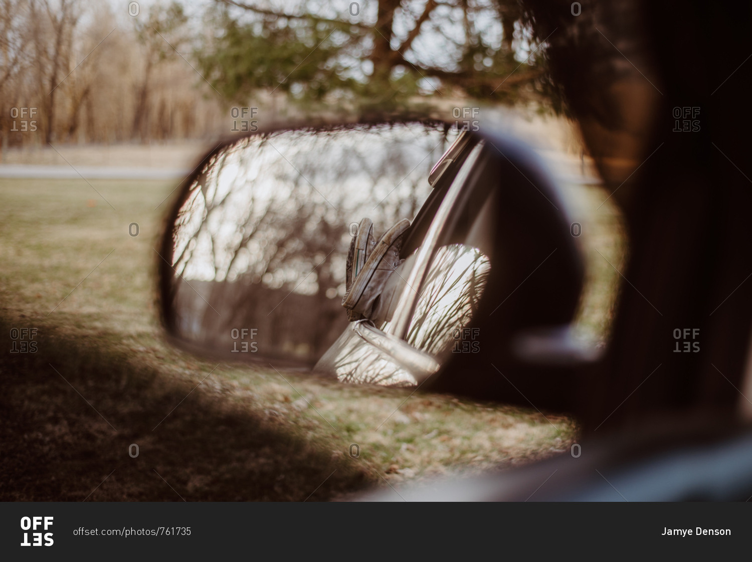 Reflection in side mirror of person sticking feet out car window
