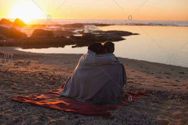 Couple romancing on beach during sunset