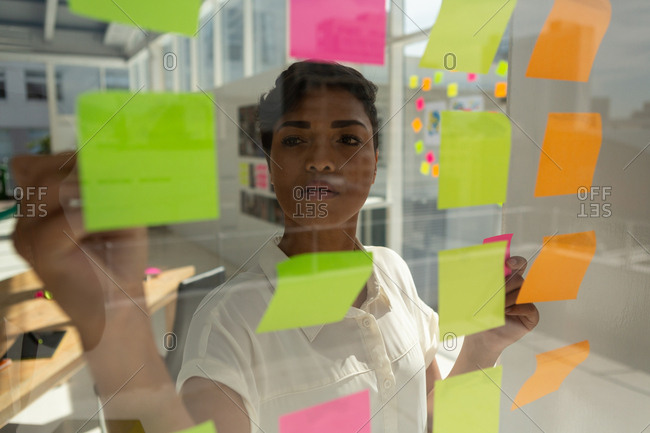 Business executive working on sticky notes in office