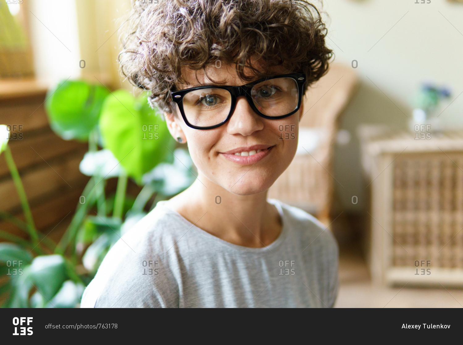 Portrait of woman with curly hair wearing retro glasses ...