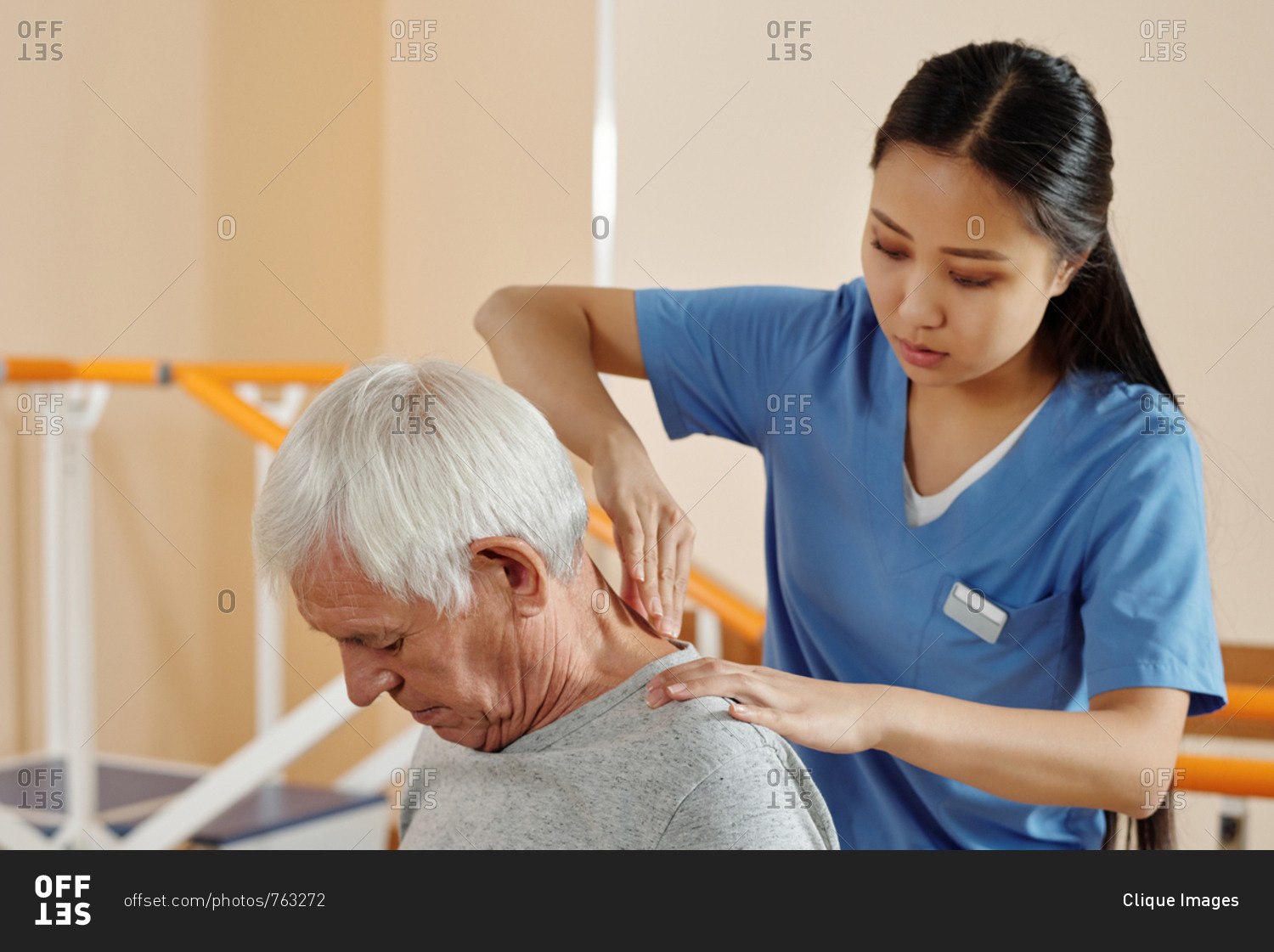 Young professional Asian nurse giving therapeutic massage to Caucasian ...