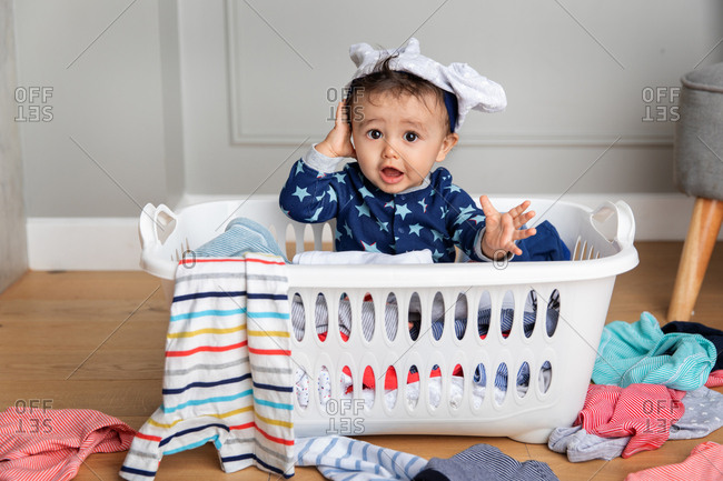 Cute baby sitting in a laundry basket