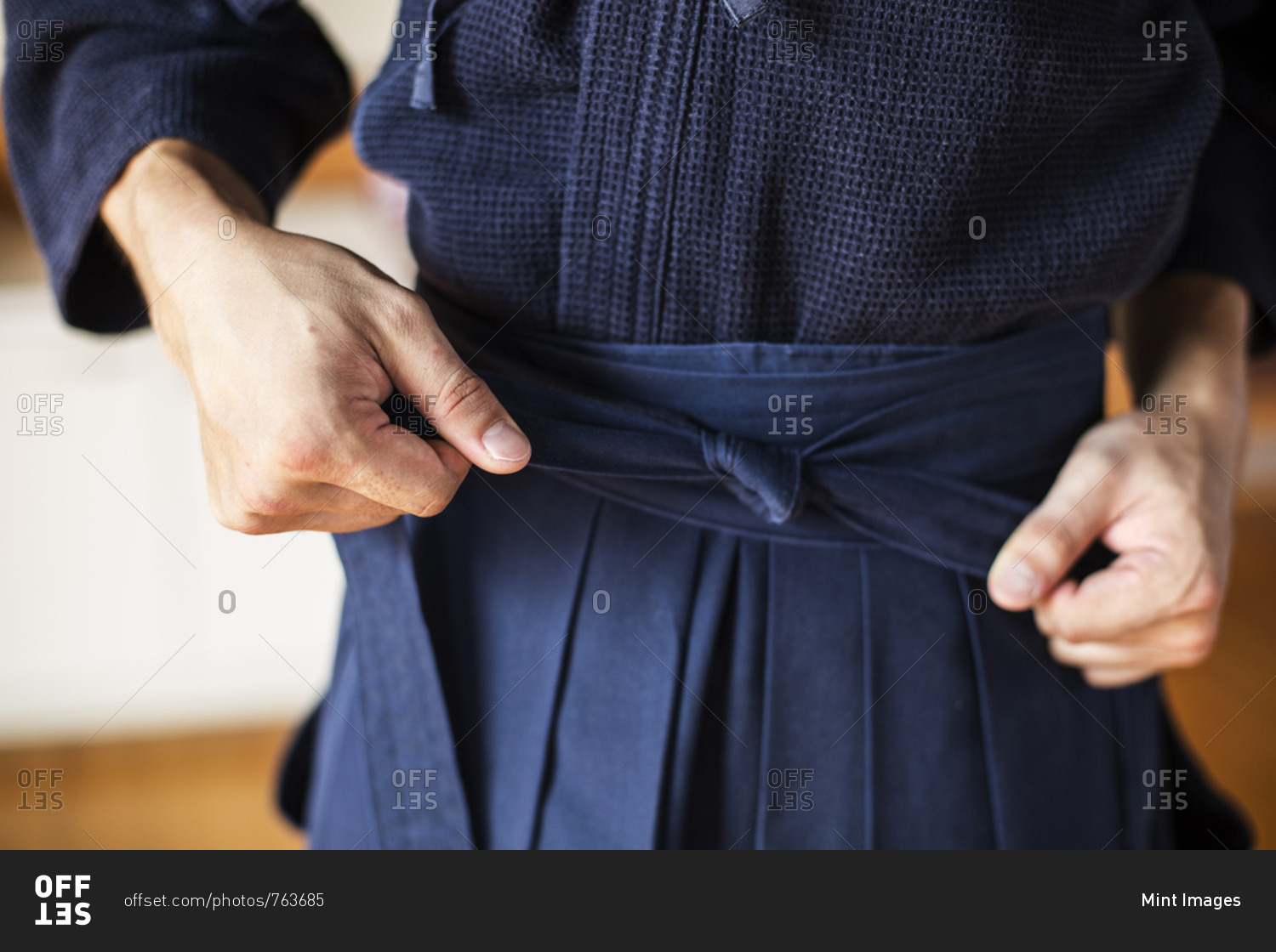 Close up of Kendo fighter tying belt of blue Kendo uniform. stock photo