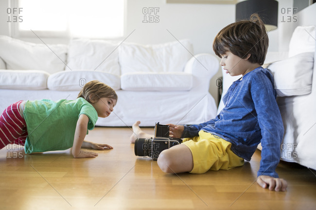 Two brothers at home exploring an old-fashioned film camera