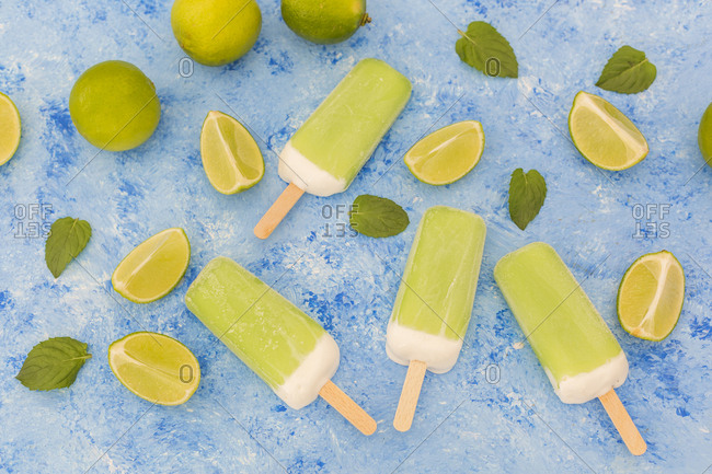 Lime mint popsicles- limes and mint leaves on light blue background