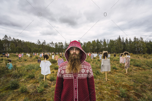 Finland-  Suomussalmi- Man standing in front of The Silent People- art project with crowd of scare crows