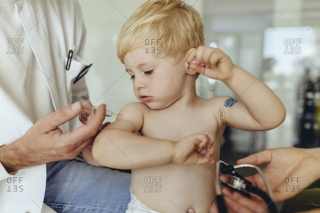 Pediatrician vaccinating toddler- injecting infant's arm