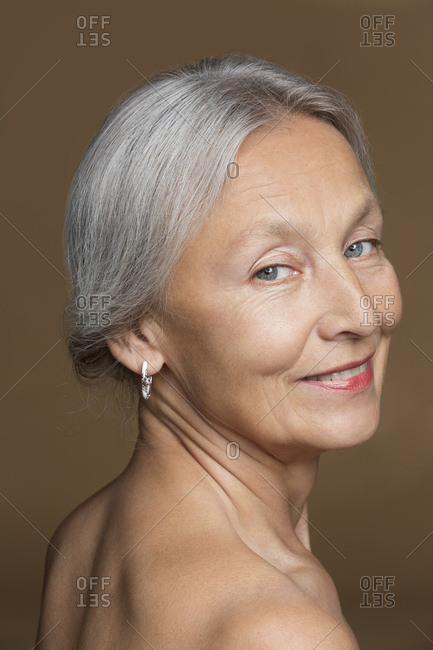 Portrait Of Naked Senior Woman With Grey Hair In Front Of