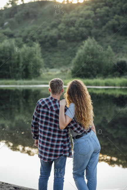 Romantic couple standing at the riverside- embracing
