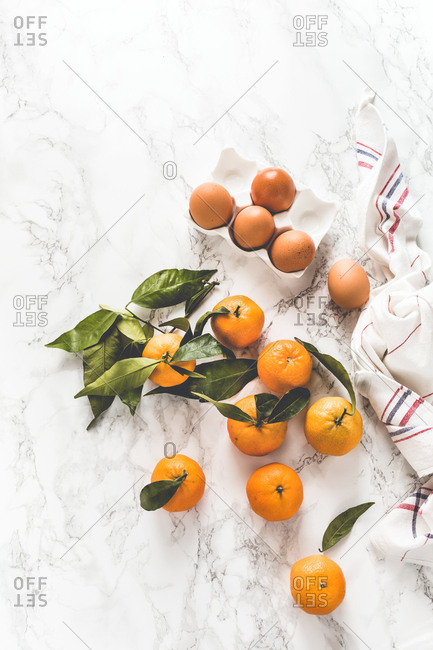 Fresh clementines with green leaves on light background