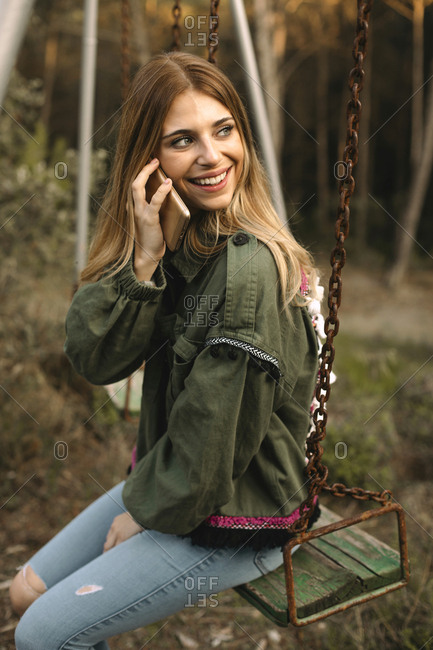 Pretty Blonde Teen Doing A Selfie With The Phone Sitting On A Swing In Nature Stock Photo Offset