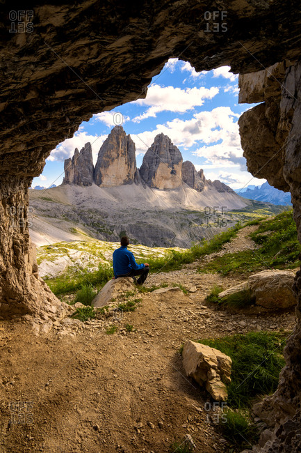 Hiker admires the three peaks of Lavaredo from the caves, Natural Park of the Three Peaks, Trentino-Alto Adige, Italy, Europe