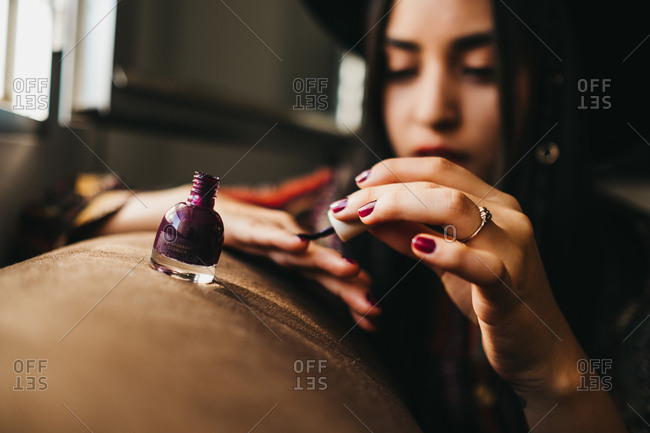 Pretty Young Female In Stylish Outfit Using Brush To Apply Nail