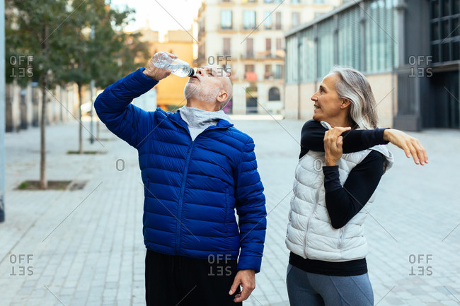 Senior couple taking a break after doing sport outdoors.