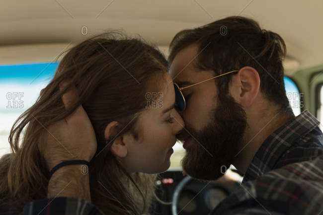 Close-up of couple kissing in vehicle on roadtrip stock photo - OFFSET Close-up of couple kissing in vehicle on roadtrip stock photo - OFFSET