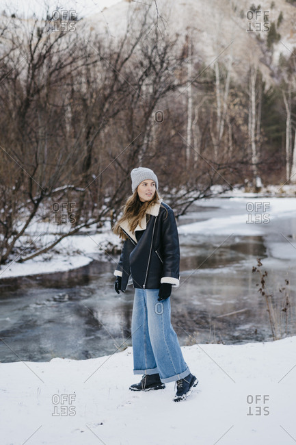 beautiful girl posing against the backdrop of the winter forest and the river