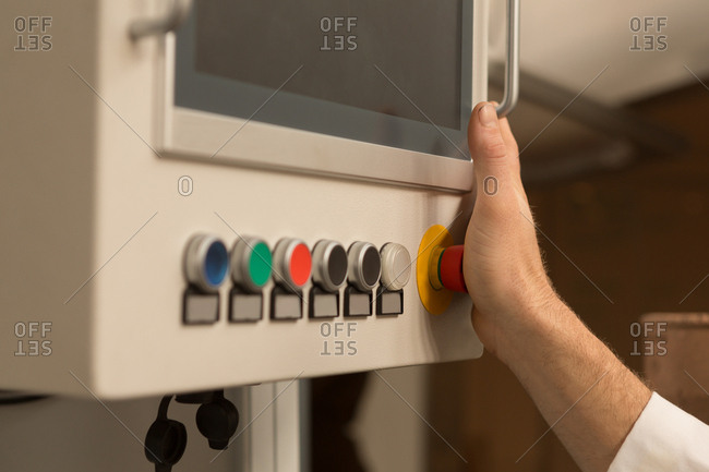 Close-up of robotics engineer controlling control panel in warehouse