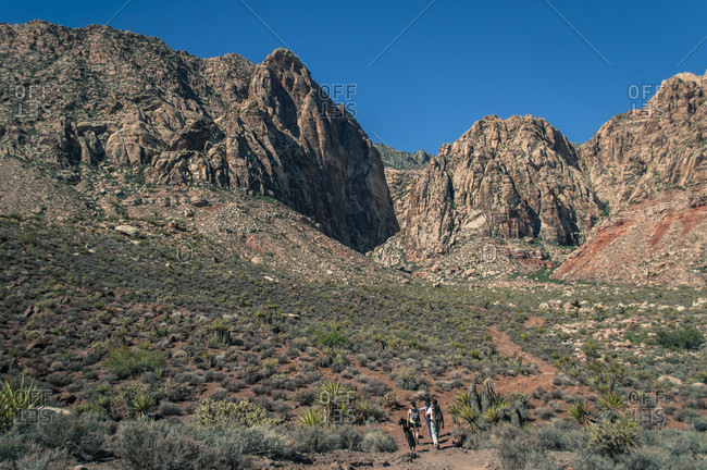 Distant view of group of people walking towards canyon in Red Rock Canyon National Conservation Area, Nevada, USA