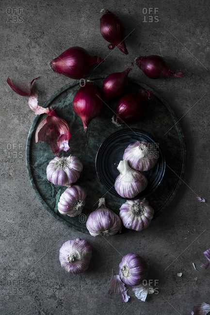 Beautiful still life of garlic and red onions photographed in a dark moody setting