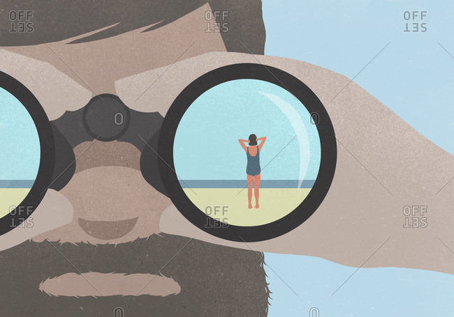 Reflection of woman standing on beach in binoculars held by a man with a beard