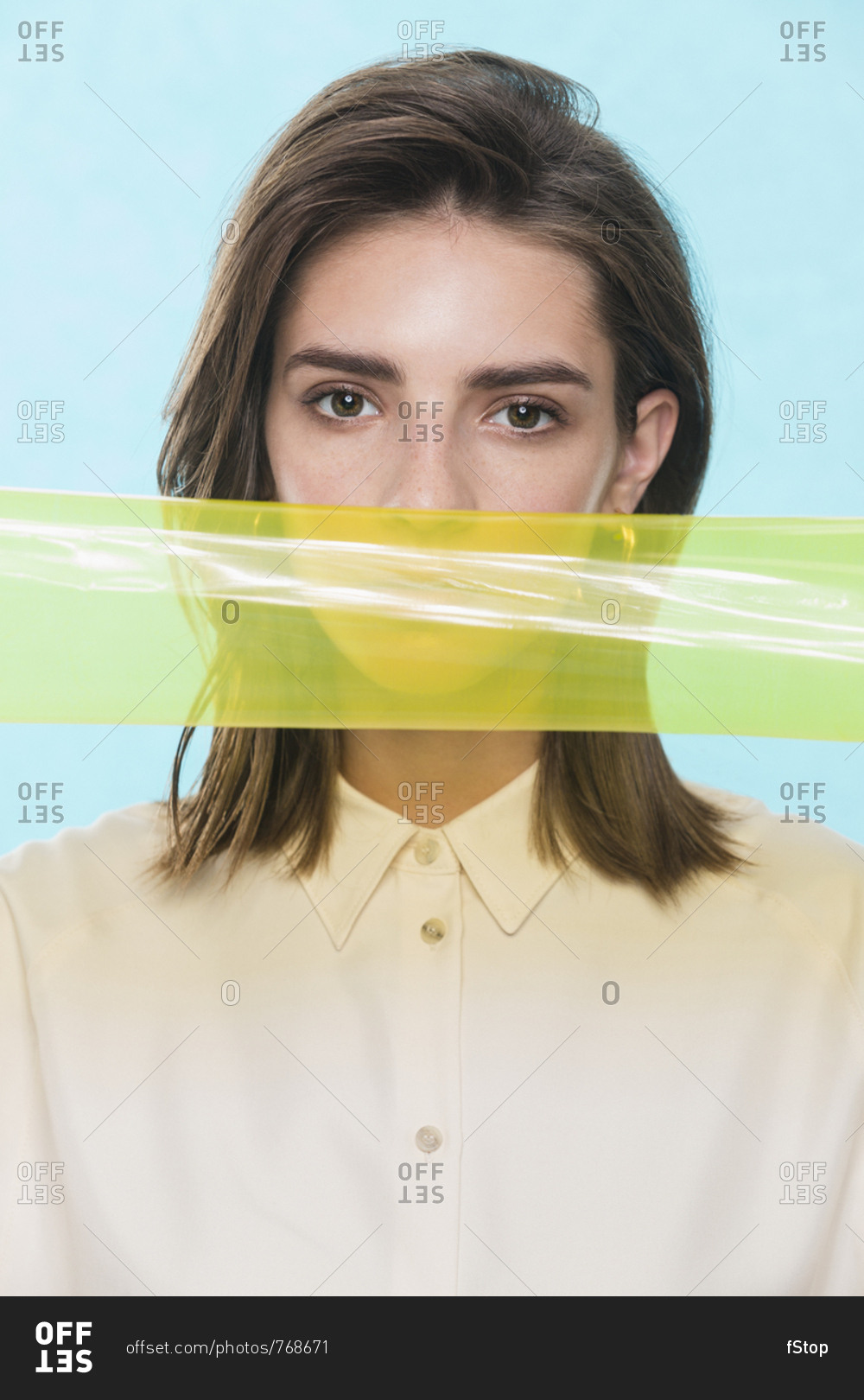 Portrait of a female fashion model posing with yellow plastic strip