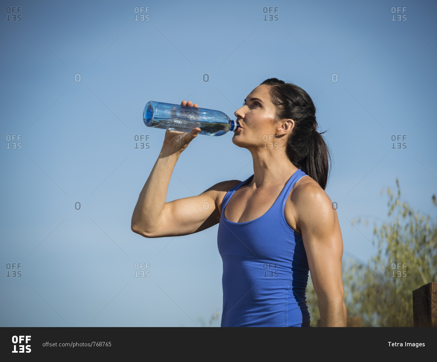 Woman in sportswear drinking from water bottle