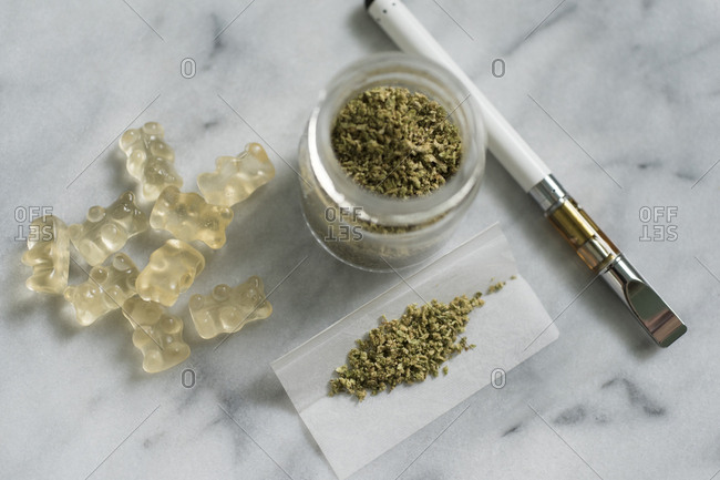 Gummi bear edibles, marijuana in jar and rolling paper, and electronic cigarette