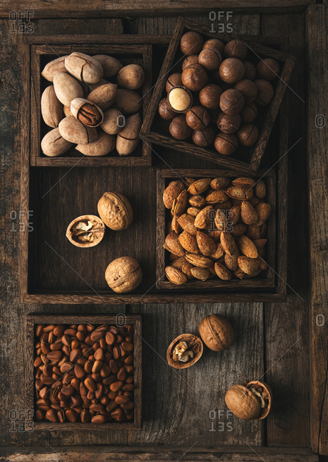 Variety of nuts in shells sorted in rustic wooden boxes