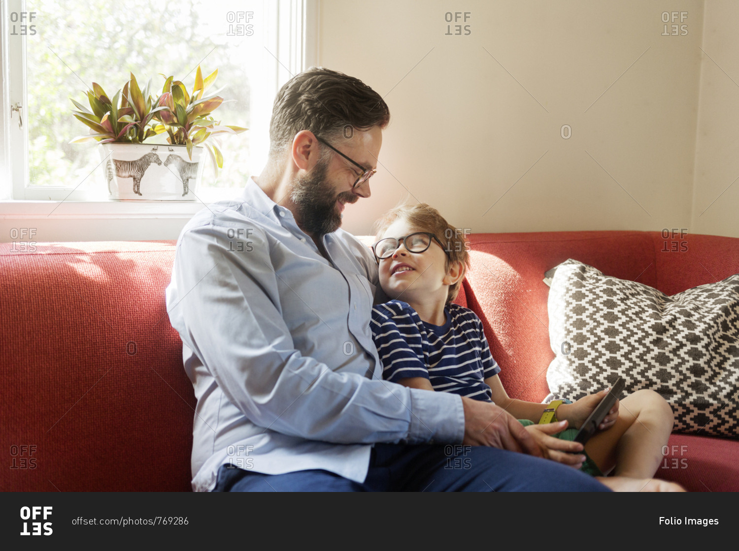 Mid Adult man and boy using a device in a living room in Sweden