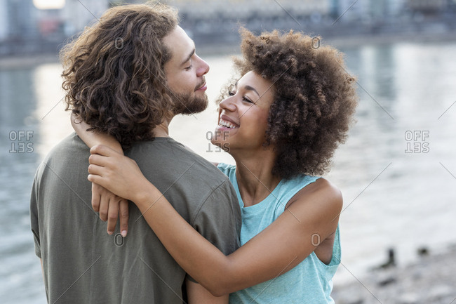 Happy young couple hugging at the riverside