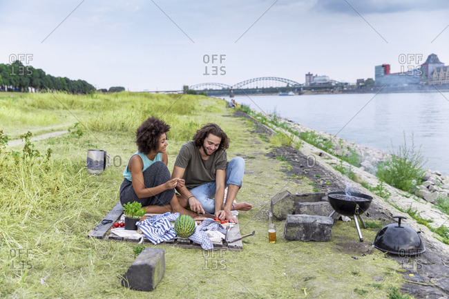 Germany- Cologne- couple having a barbecue at the riverside