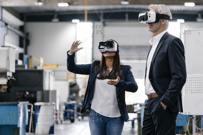 Businessman an woman in high tech enterprise- using VR glasses
