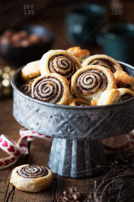 Bunch of tasty fresh buns lying in metal bowl on wooden tabletop