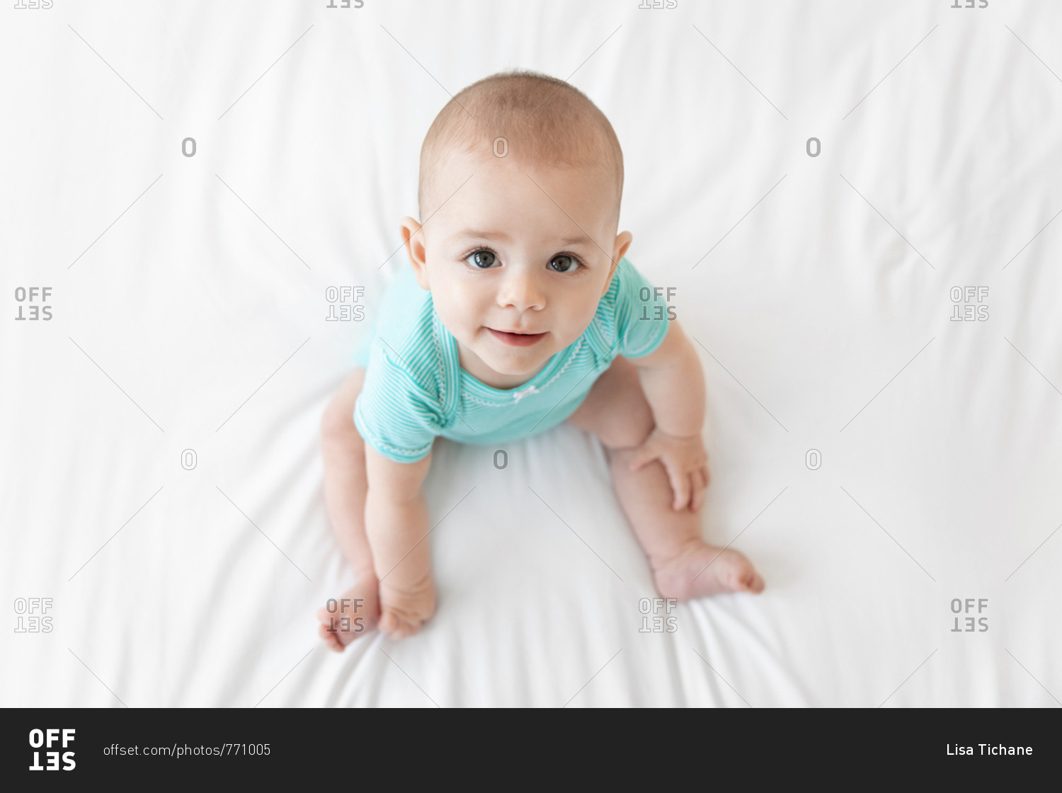 Happy baby in teal onesie from above