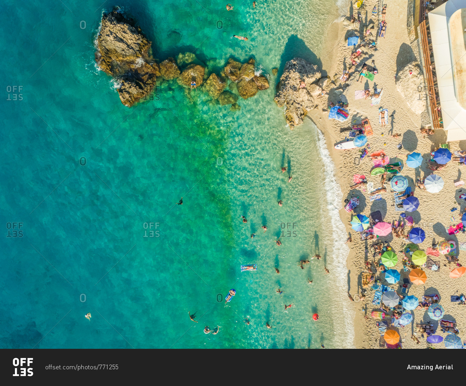 Aerial view of crowded beach with vacationers and parasols, Lefkada, Greece.