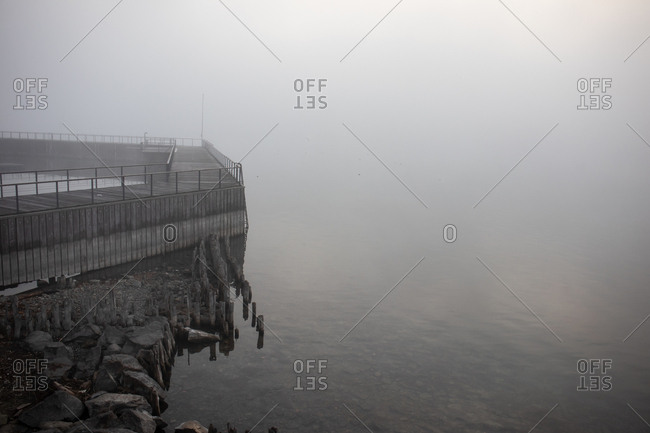 Wooden pier by the ocean on a foggy day
