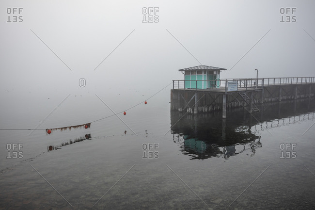 Floats and building at the end of a pier on a foggy day