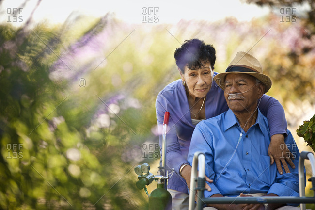 Senior woman hugging her husband with nasal tubes.