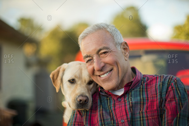 Portrait of a smiling senior man with his dog.