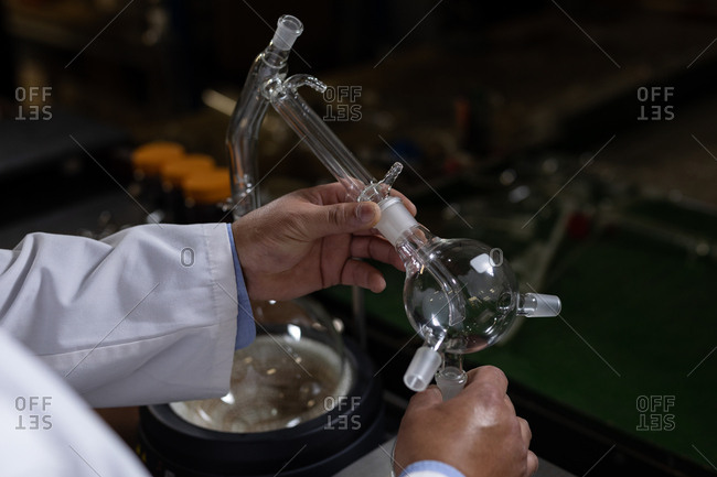Close-up of worker examining glass product in glass factory