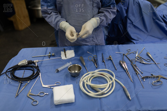 Mid section of surgeon holding medical tools in hospital