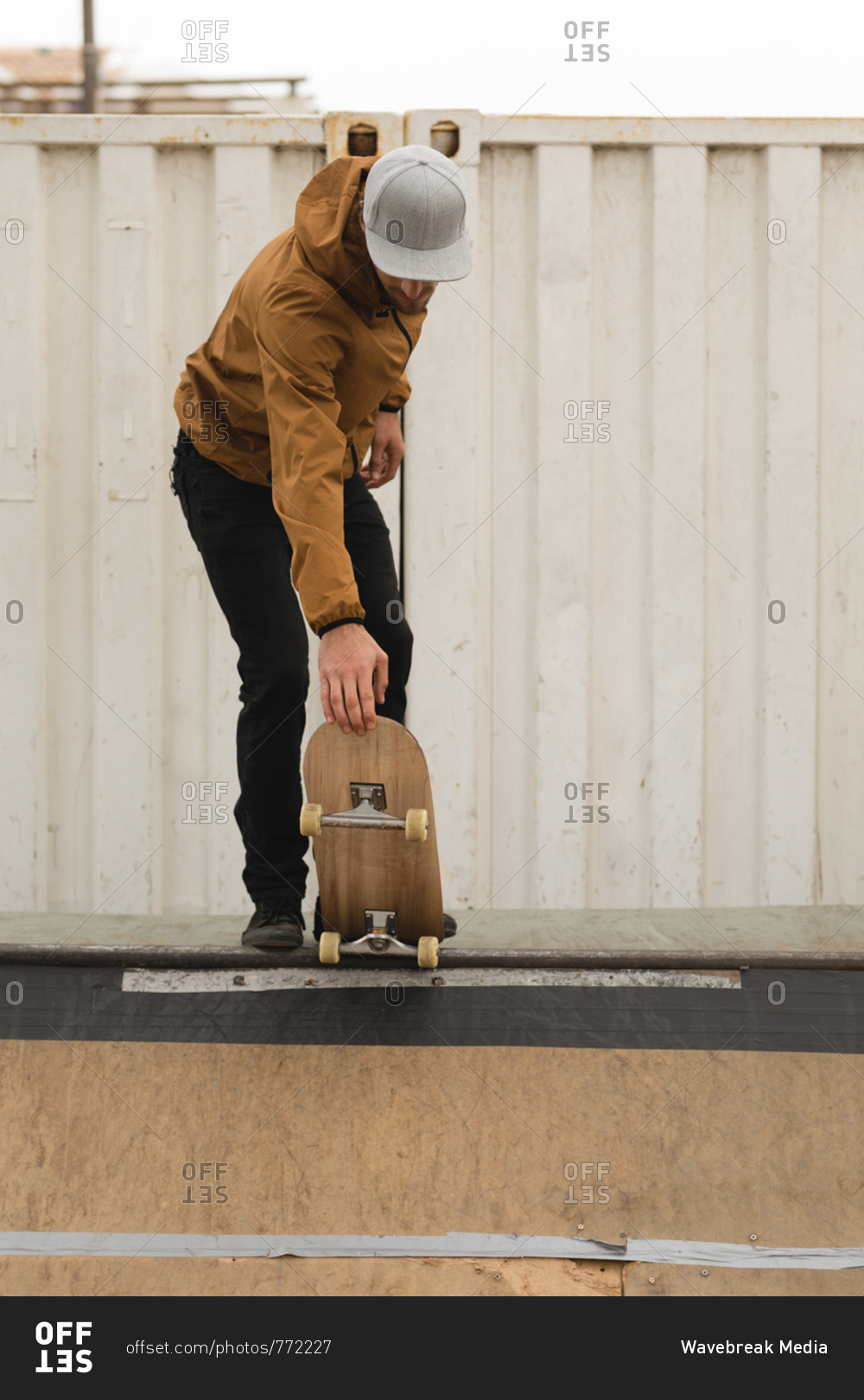 Stylish male skateboarder skating on skateboard ramp at skateboard court