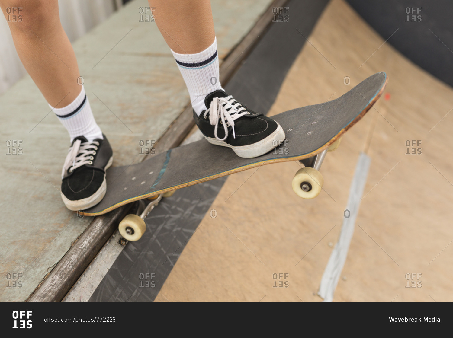 Close-up of female skateboarder skating on skateboard ramp at skateboard court