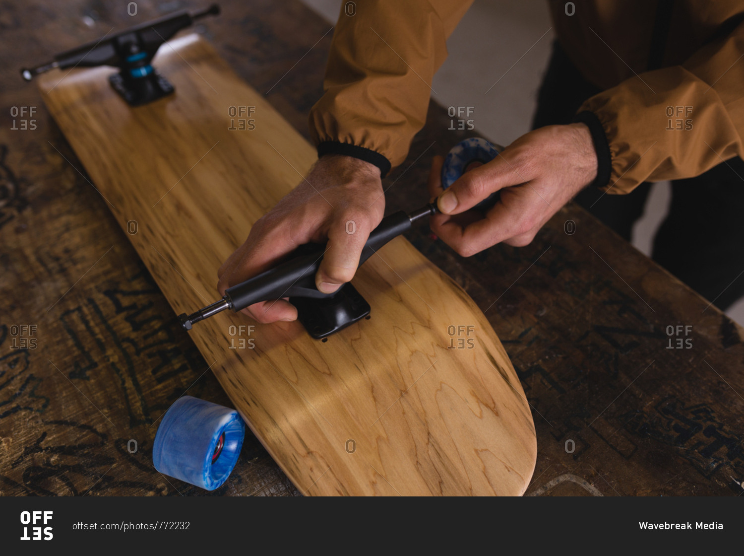 Close-up of man repairing skateboard in workshop